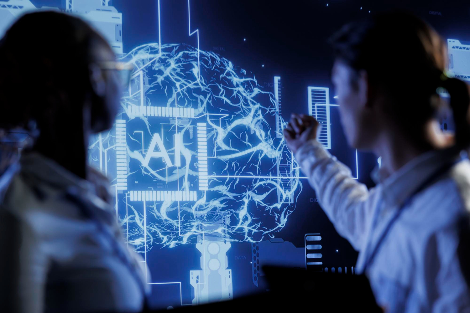 Two professionals discussing an AI visualisation on a large screen